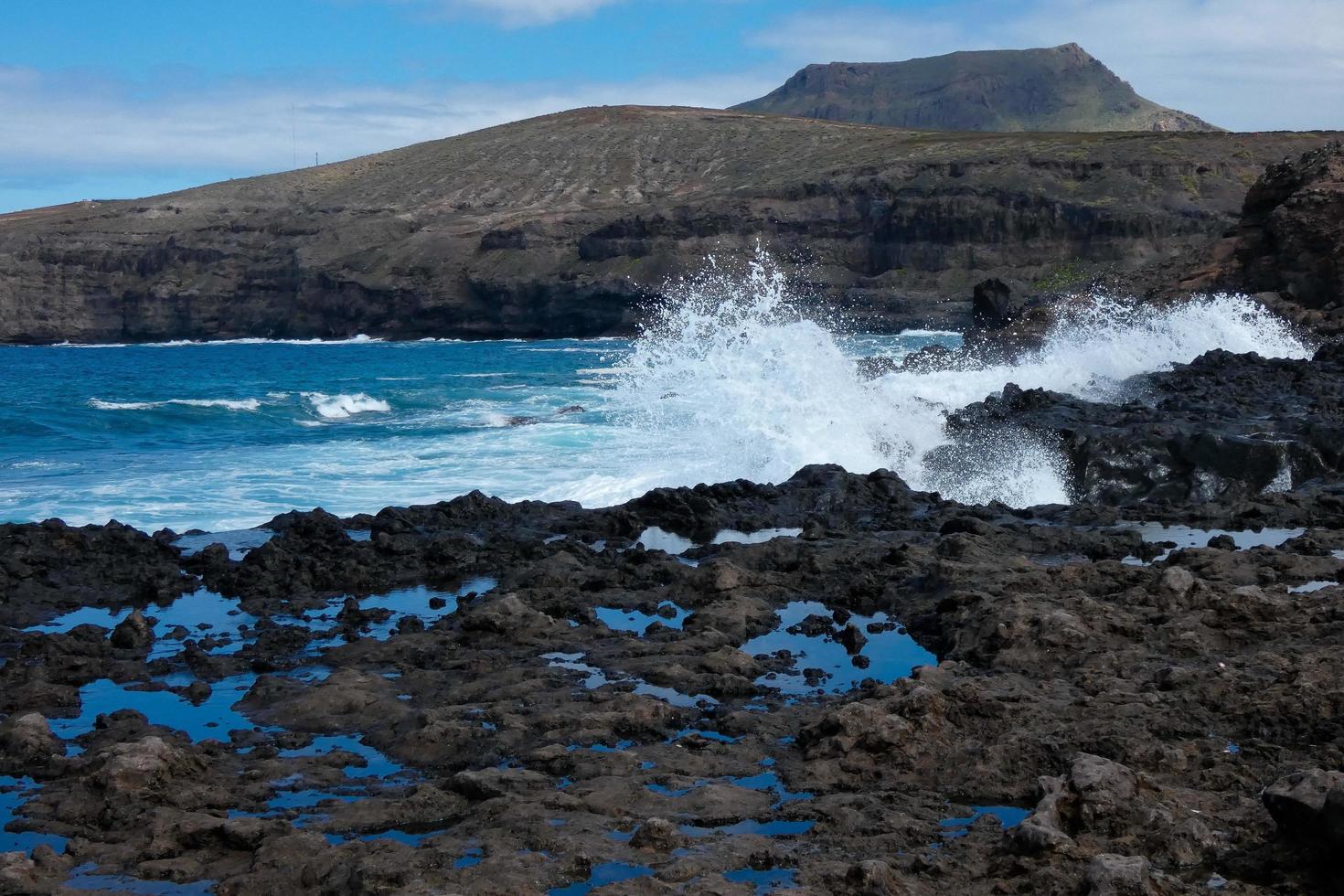 Large waves crashing against the rocks in the ocean photo