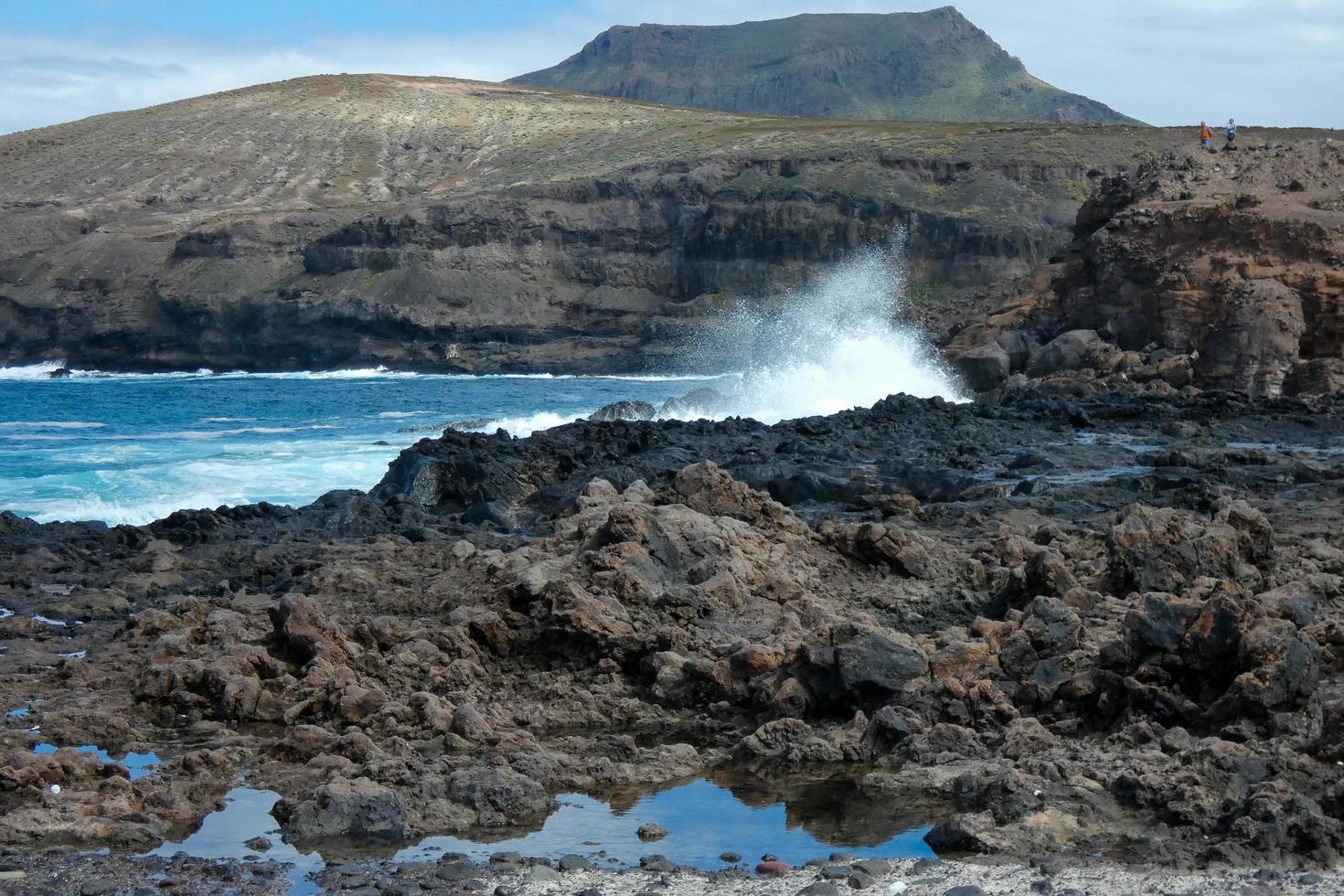 Large waves crashing against the rocks in the ocean photo