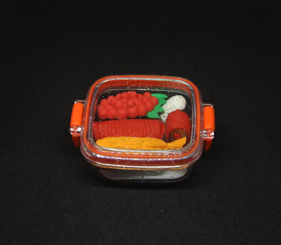 Japanese food sushi small eraser toy miniature stationary with unique cute shape. A bunch of cute sushi shaped eraser inside mini bento red plastic lunch box. photo