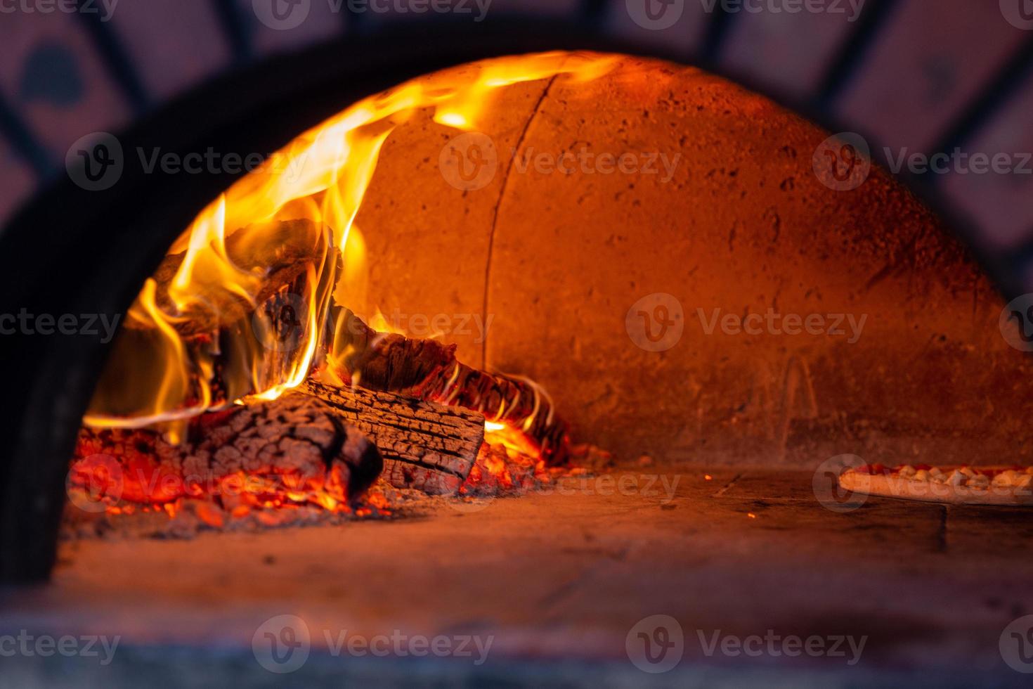 A pizza being cooked in a brick oven photo