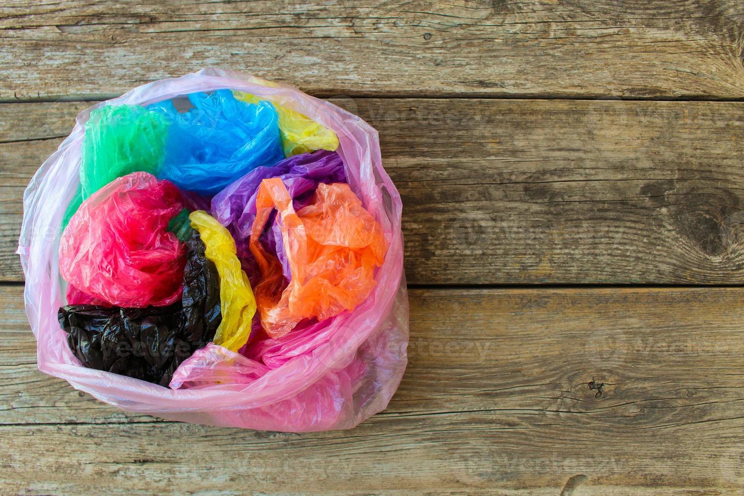 Different plastic bags on wooden background. photo