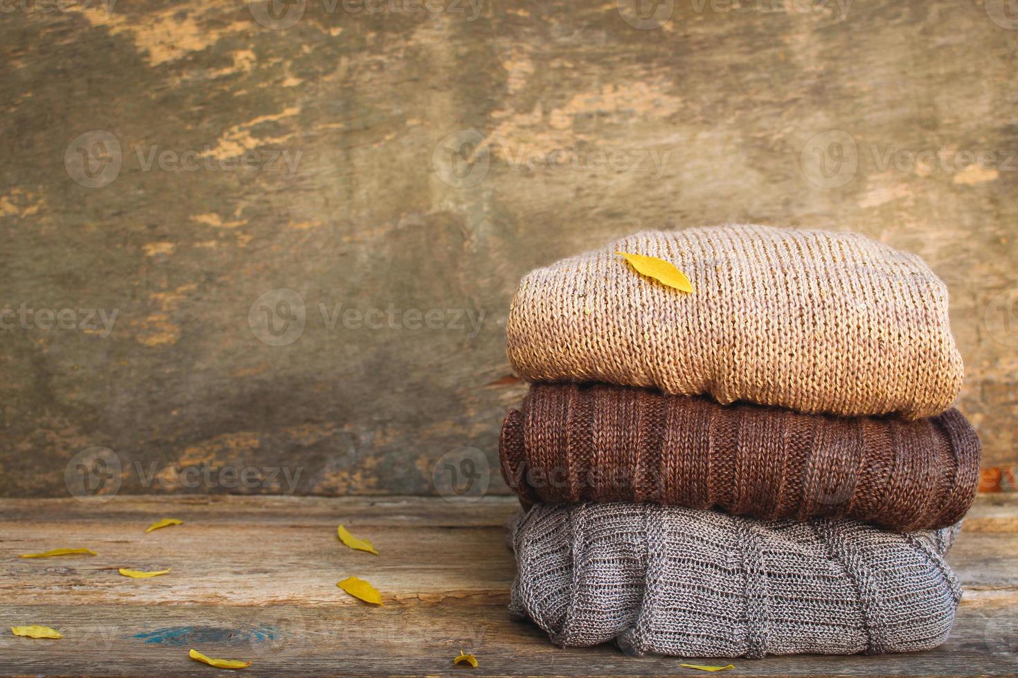 Pile of colorful warm clothes on wooden background. Toned image. photo