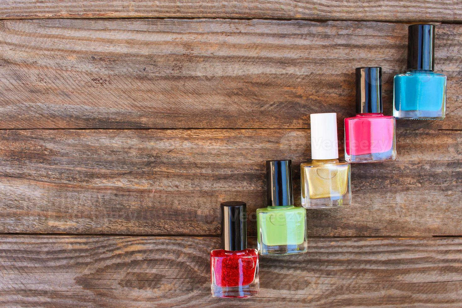 Nail polish on the old wooden background. Top view. photo