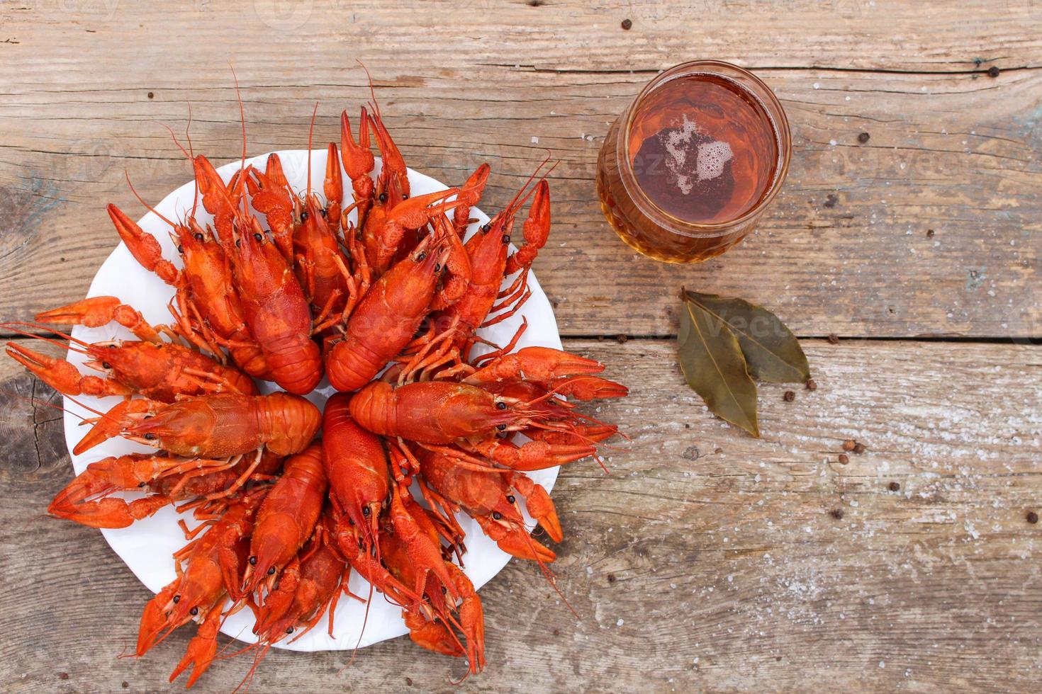 Crawfish and beer on the old wooden background. Top view. photo