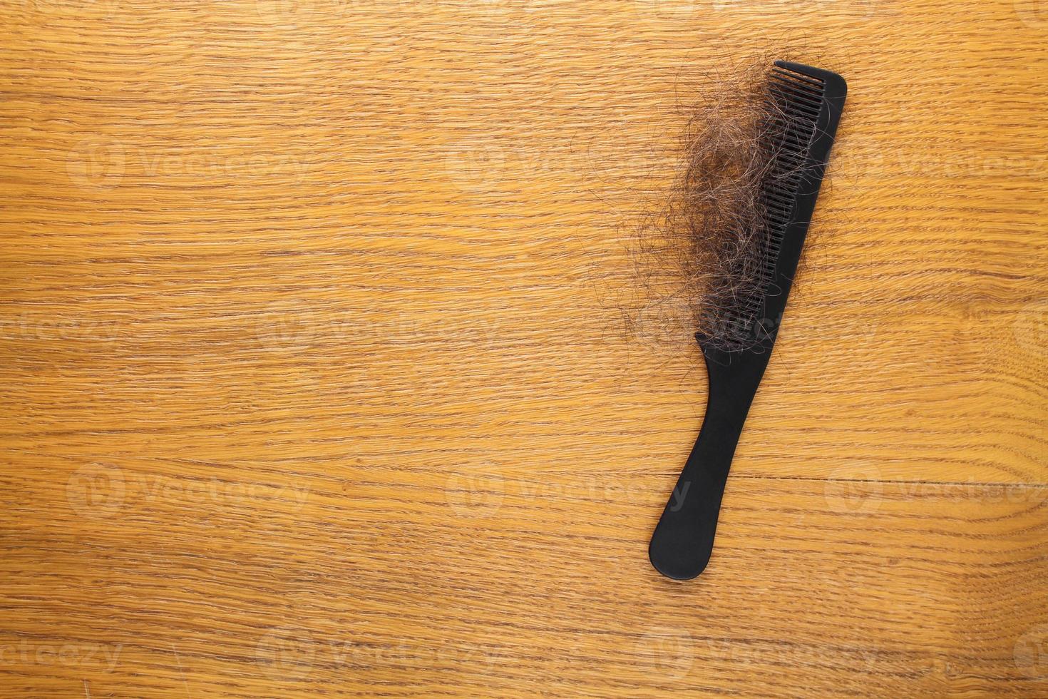 Fallen hair on comb on table. Top view. photo
