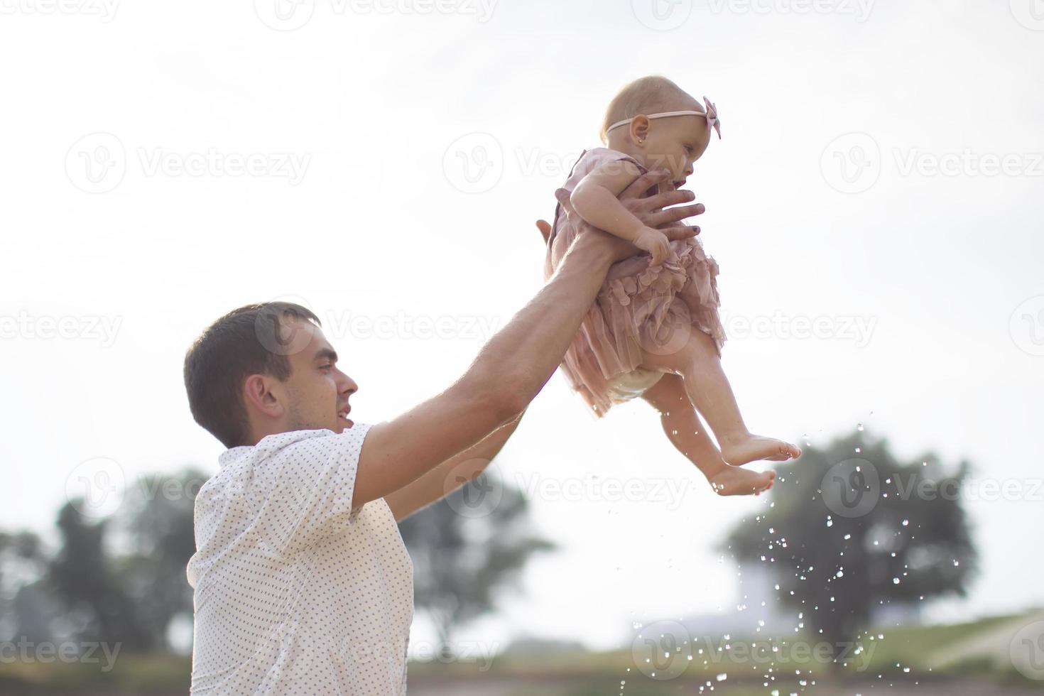 Happy dad throws up with his little daughter for a walk. Paternity. photo
