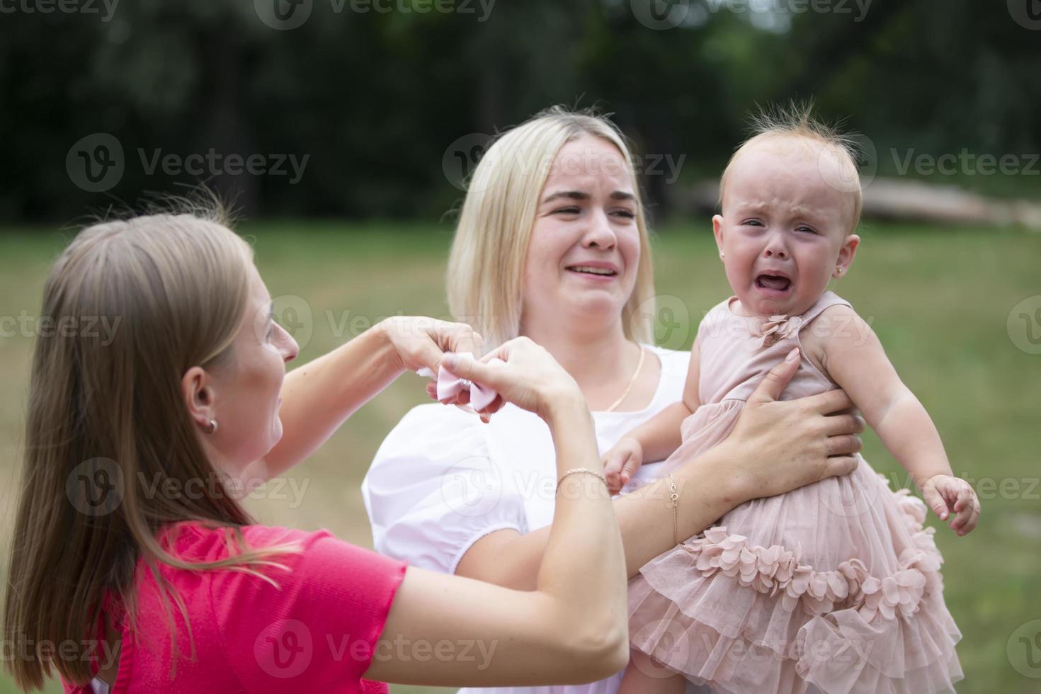 A little girl is crying in her mother's arms. photo