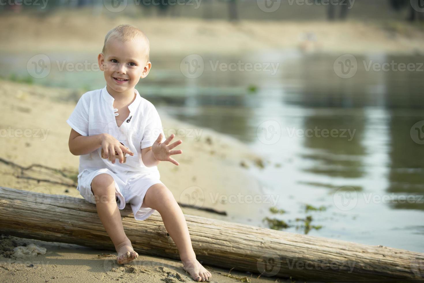 Handsome little boy is walking by the river. photo