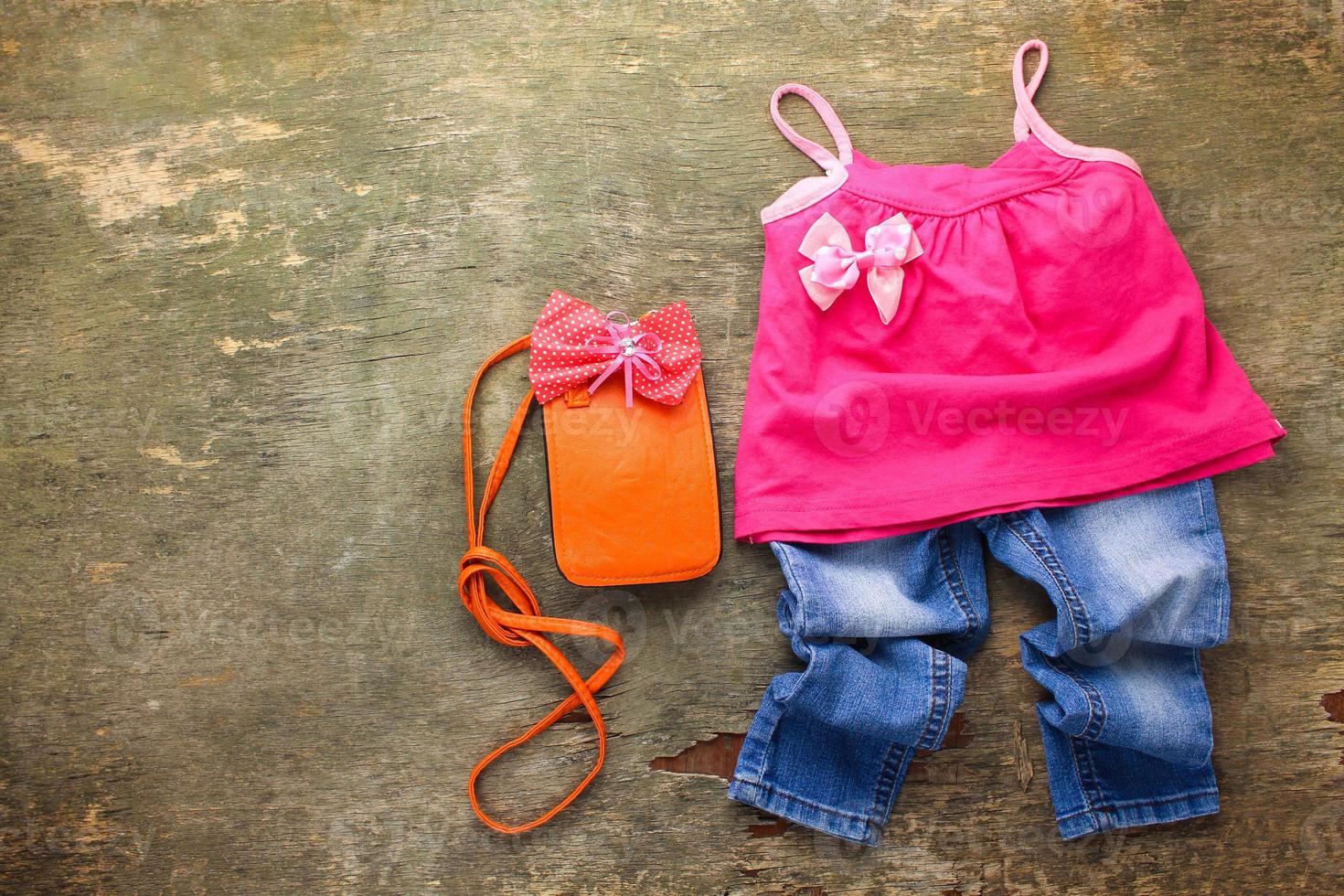 Summer children's clothing t-shirt, jeans, handbag. Top view. photo