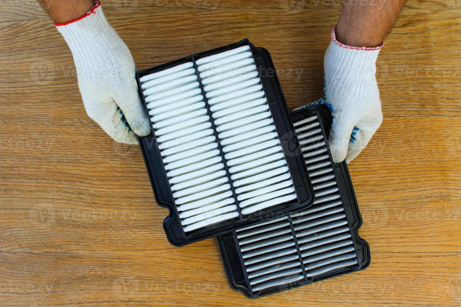 Man holds the clean and dirty filters on the car. photo