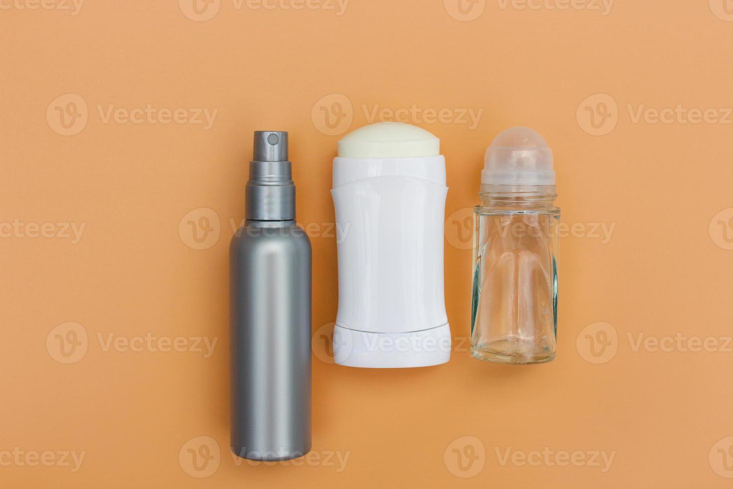 Different deodorants on beige background. Top view. photo