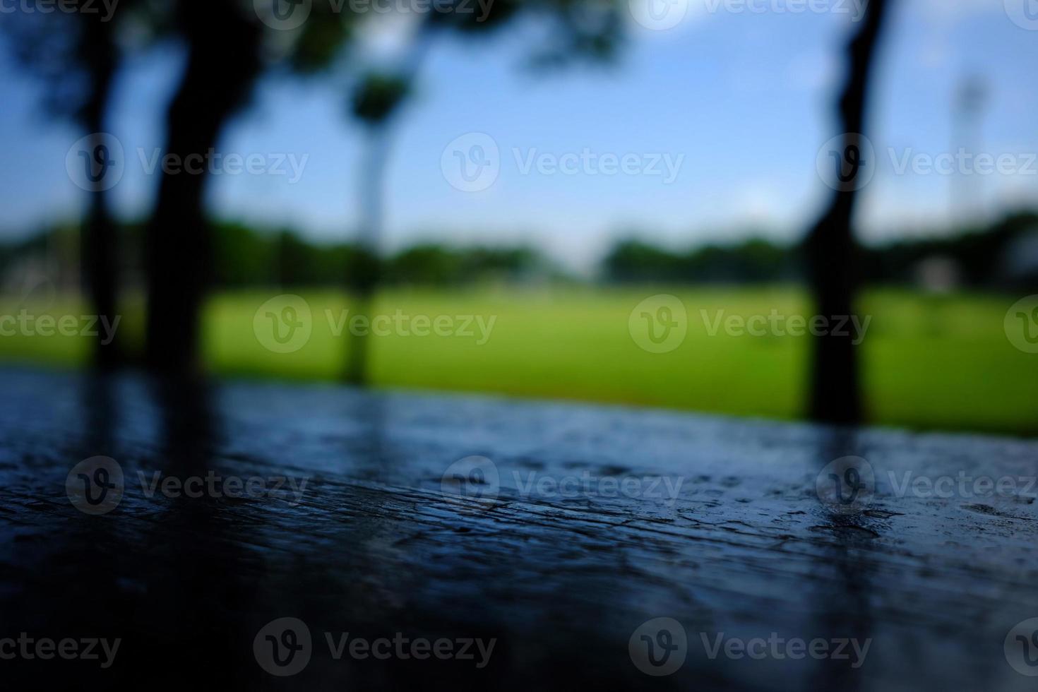 Black Wooden Table with Blurred Soccer Field Background. photo