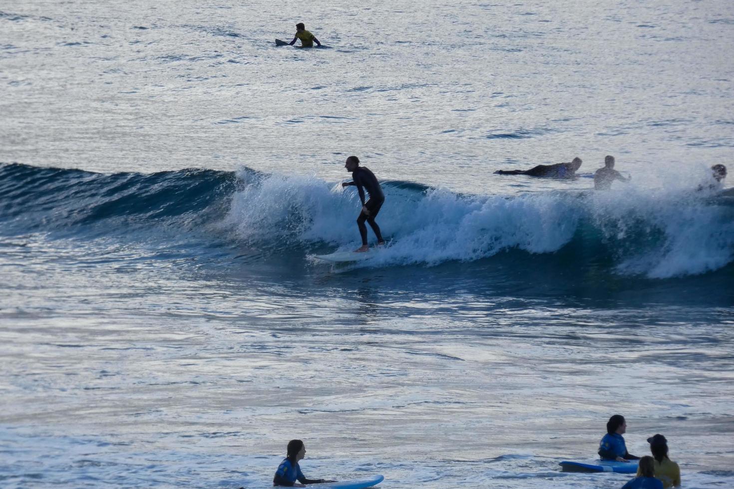 young athletes practising the water sport of surfing photo