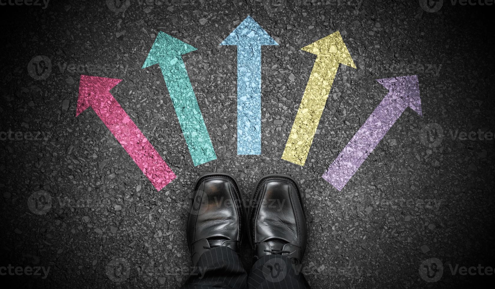 Black Business Shoes and Five Colorful Chalky Arrows on Asphalt - Direction Concept photo