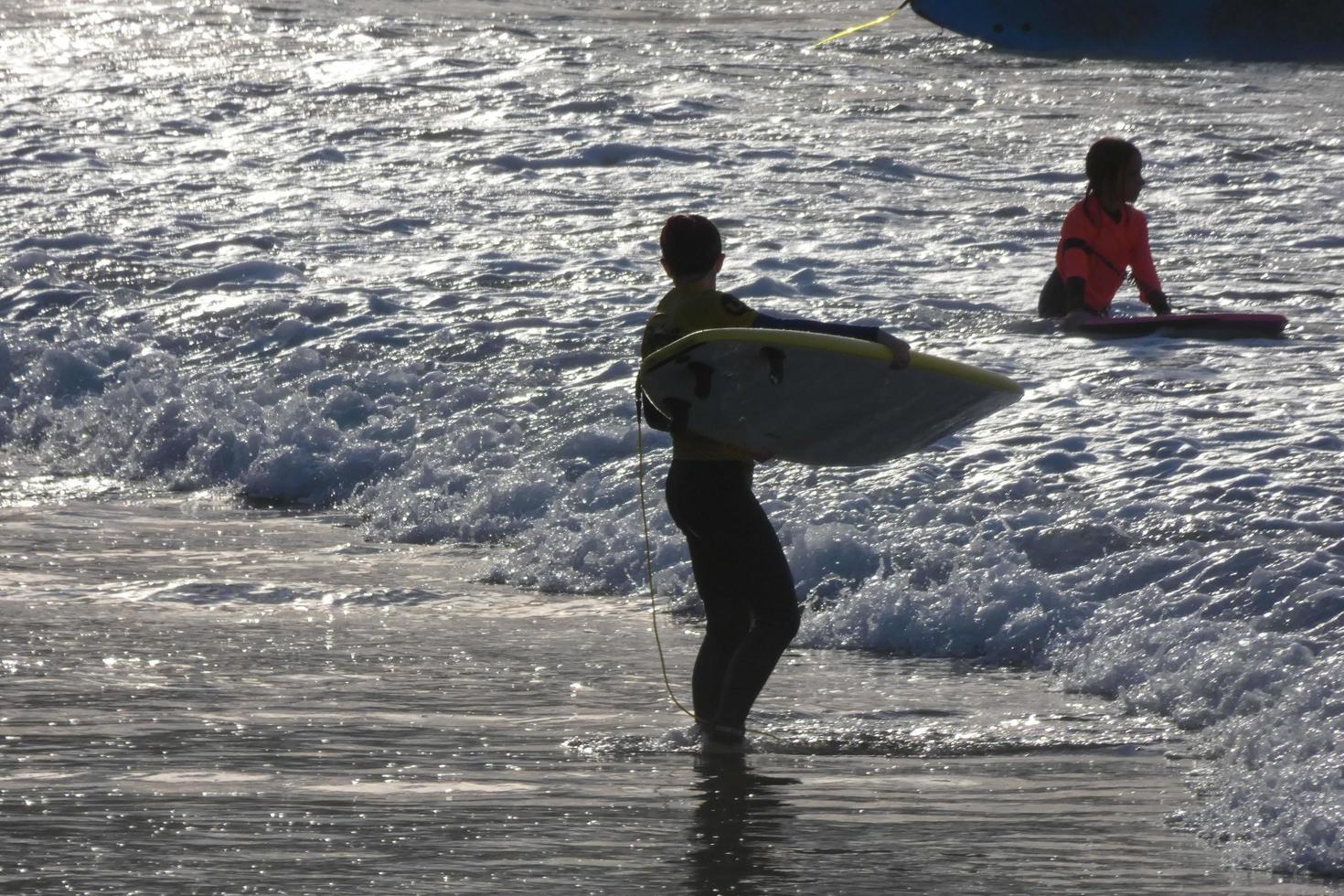 young athletes practising the water sport of surfing photo