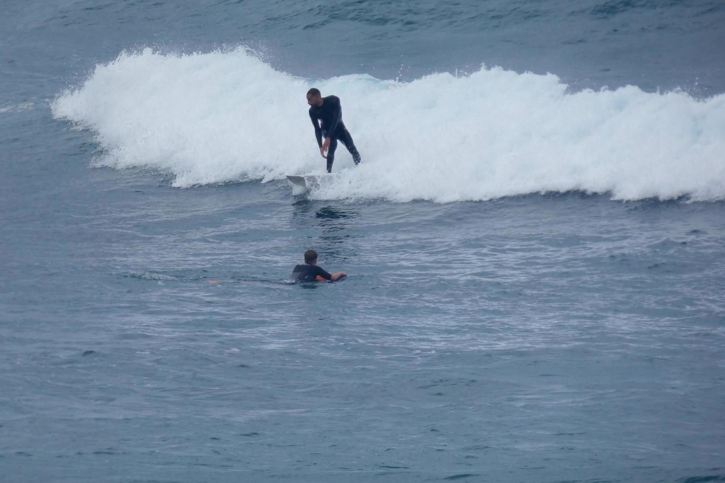 Surfers riding small ocean waves photo