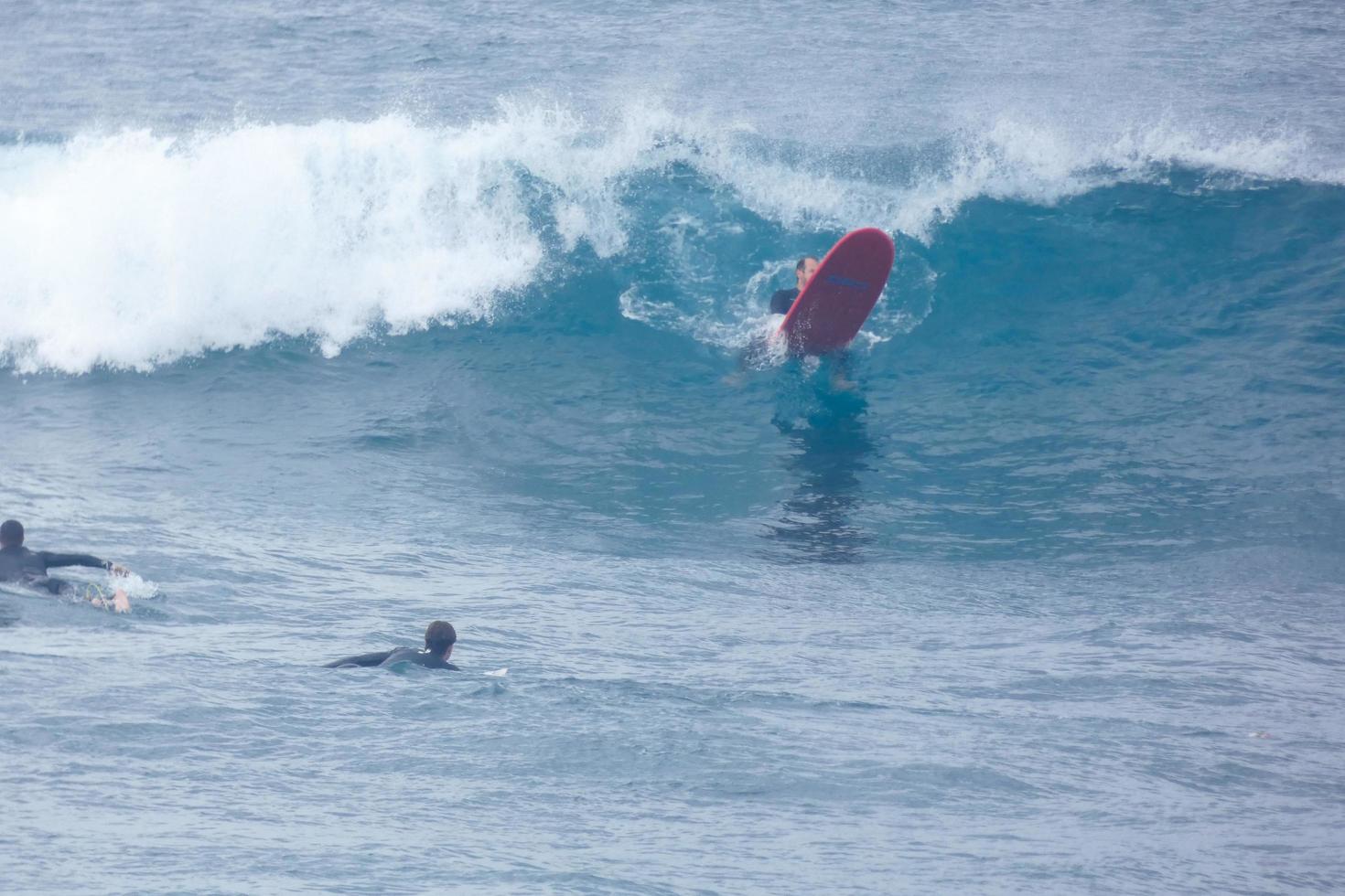 surfistas montando pequeño Oceano olas foto