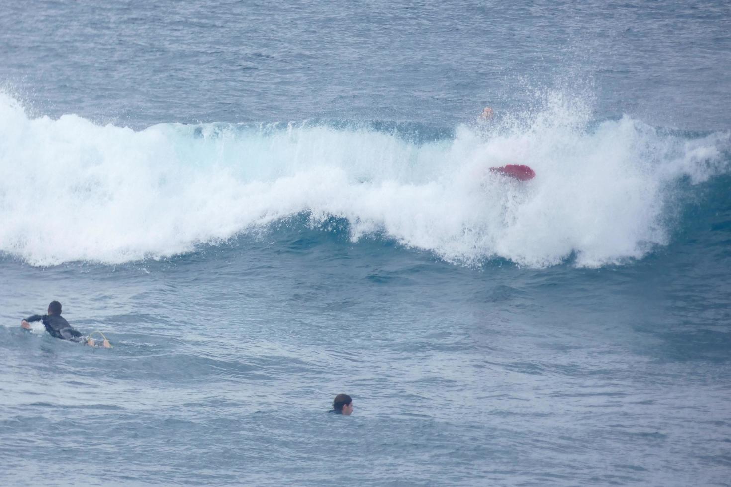 surfistas montando pequeño Oceano olas foto