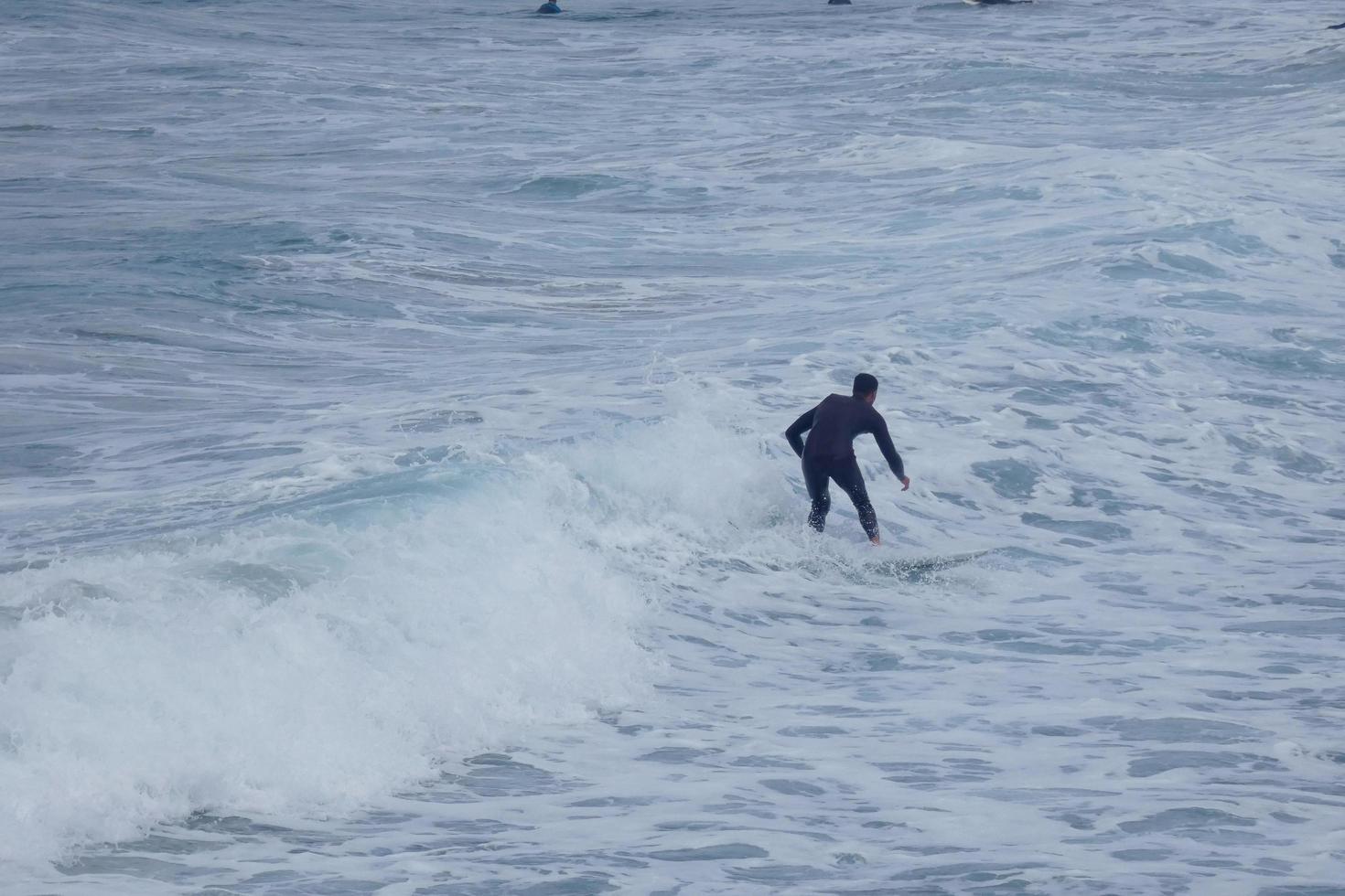 Surfers riding small ocean waves photo