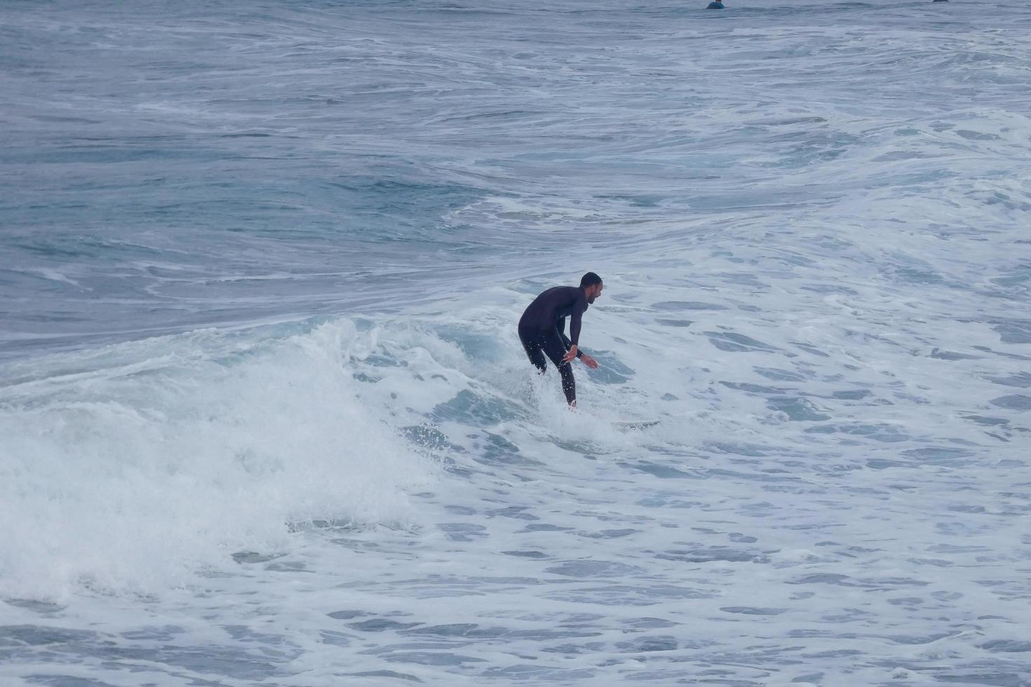 Surfers riding small ocean waves photo