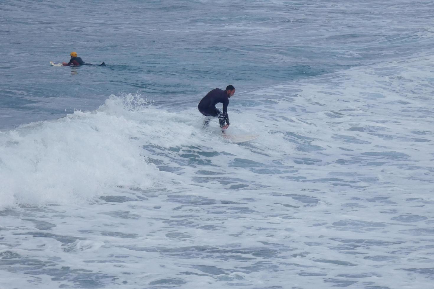 Surfers riding small ocean waves photo