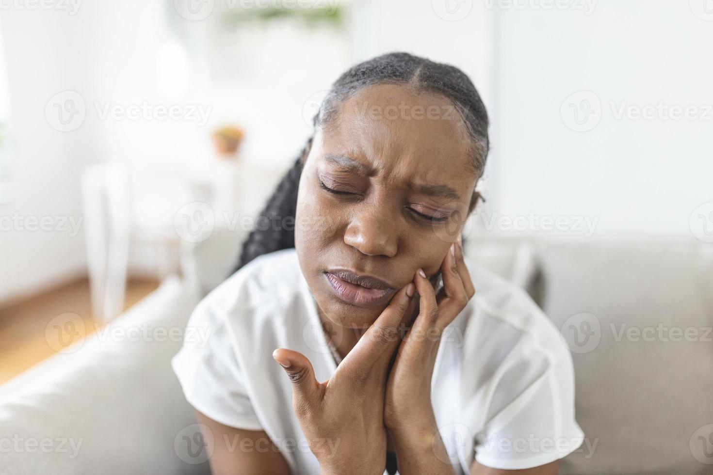 retrato de infeliz afroamericano mujer sufrimiento desde dolor de muelas a hogar. cuidado de la salud, dental salud y problema concepto. valores foto