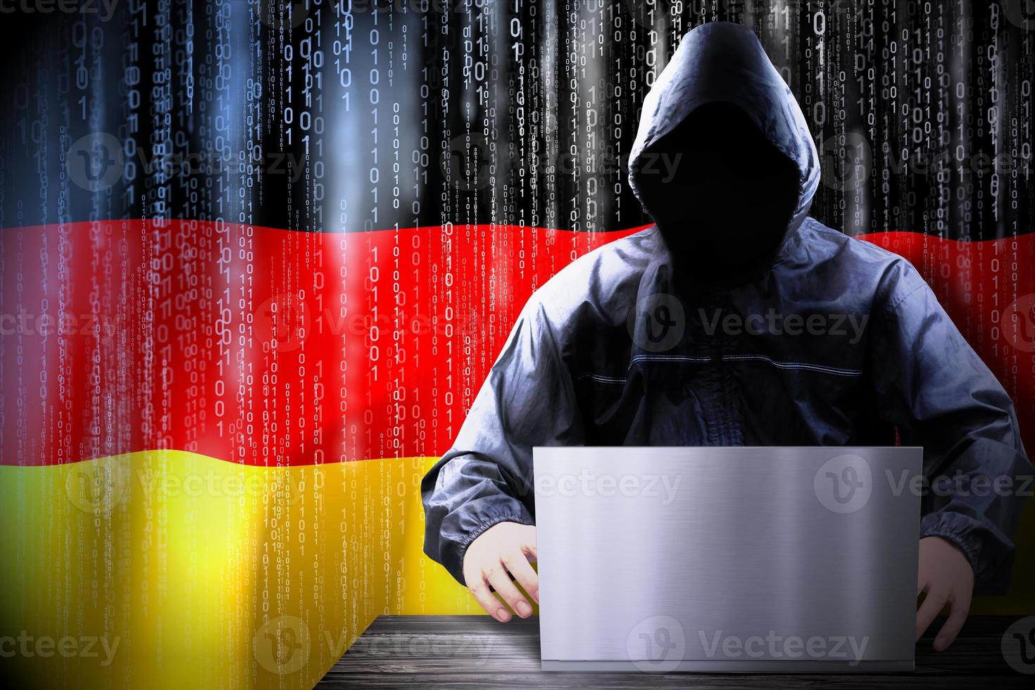 Anonymous Hooded Hacker and Flag Of Germany, Binary Code - Cyber Attack Concept photo