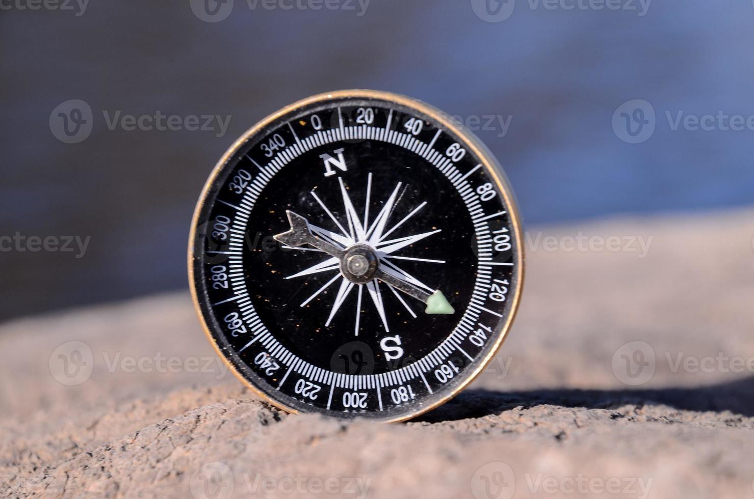 Small compass on the rock photo