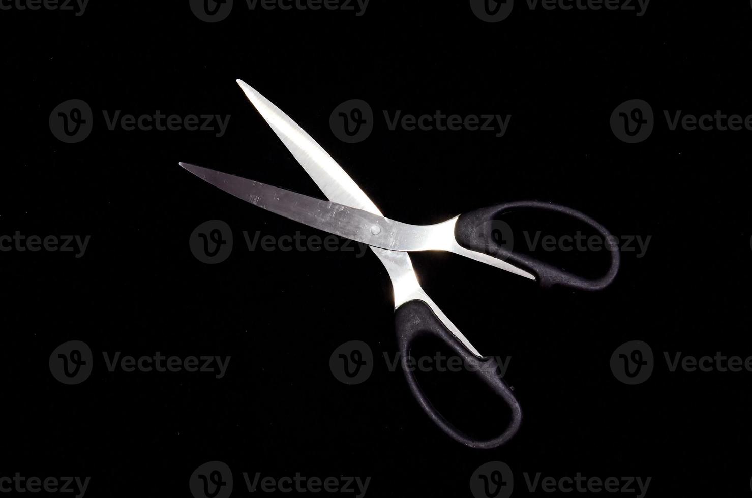 Scissors on dark background photo