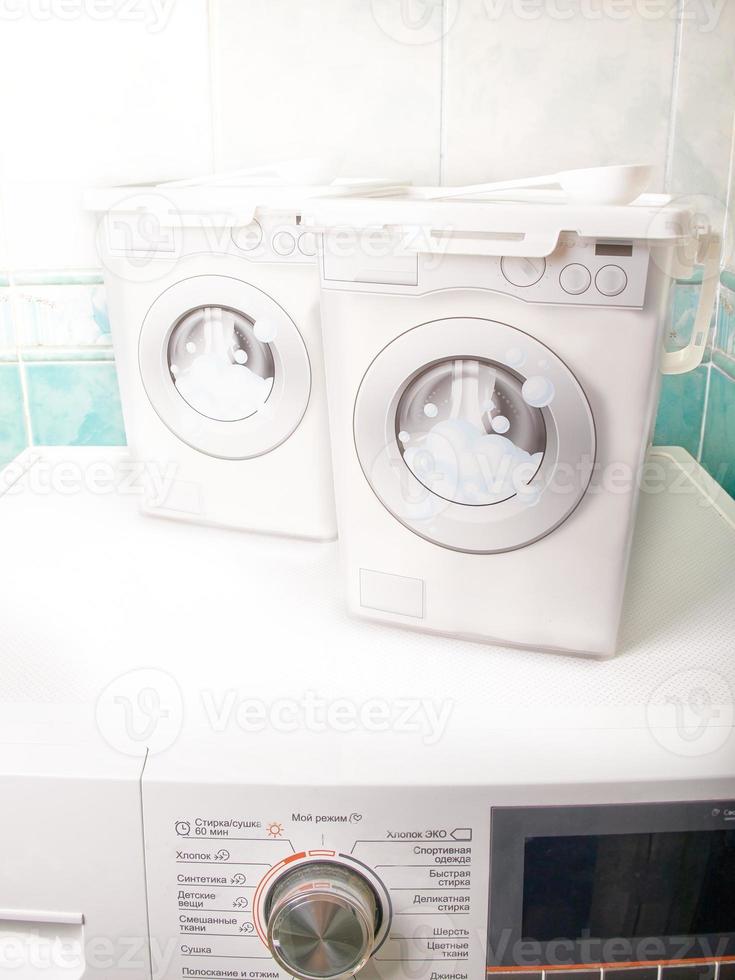 Containers for storing washing powder for different fabrics on a washing machine photo