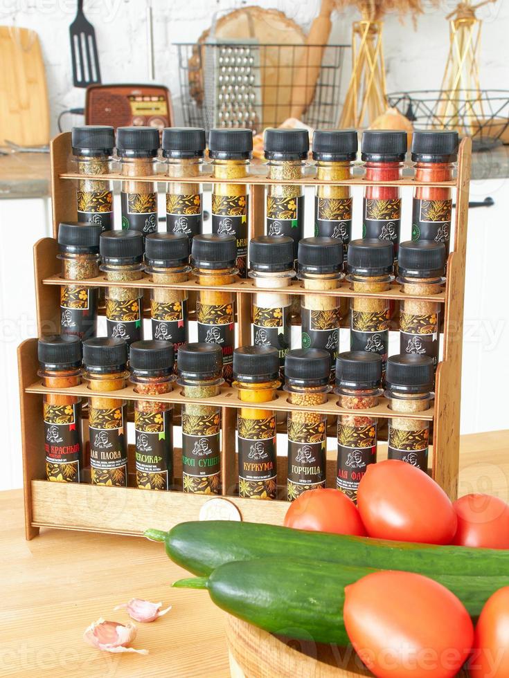 A set of glass jars with different spices in a wooden box in the kitchen. Kazan, 17 March 2023 photo