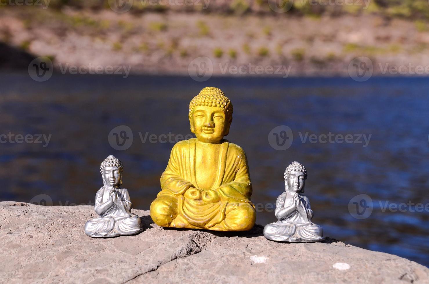 Small Buddhist statues on a rock photo