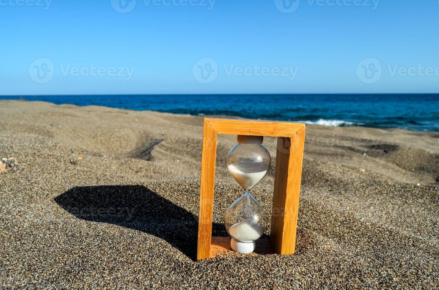 Hourglass in the sand photo