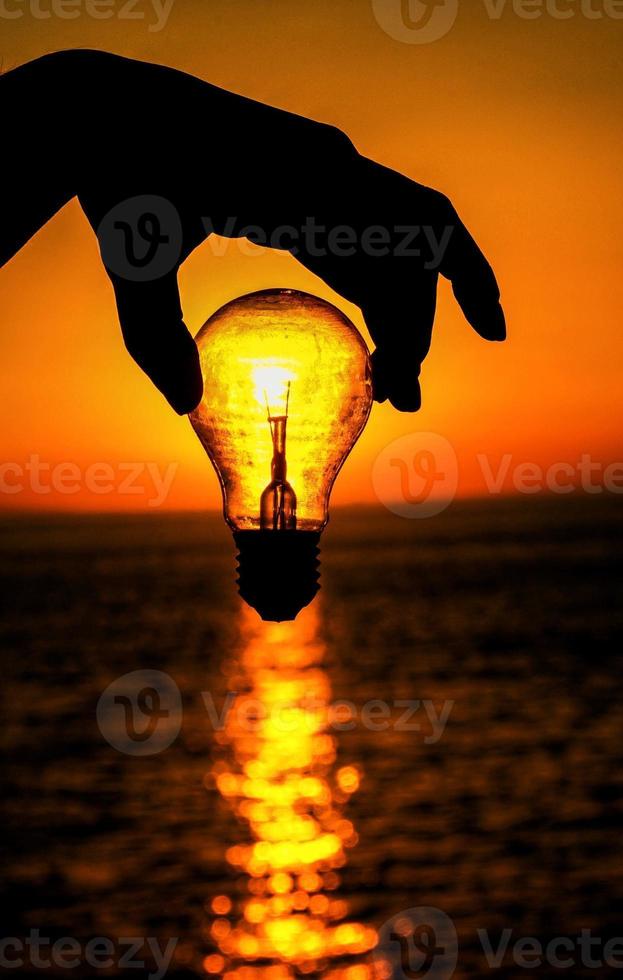 Sunset behind lightbulb photo