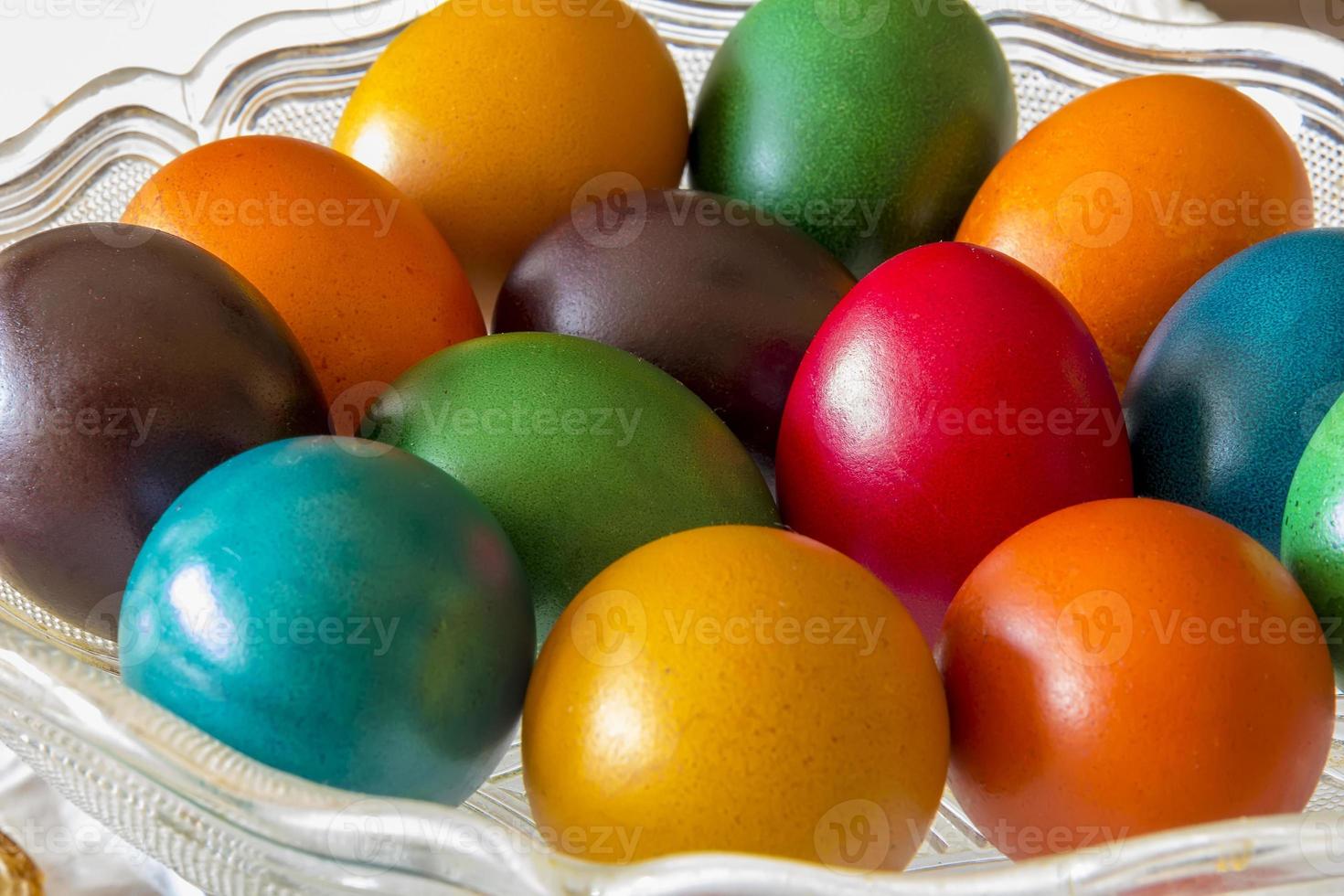 Many Easter colored eggs in the basket.  Colorful, red, green ,blue, yellow and orange eggs photo