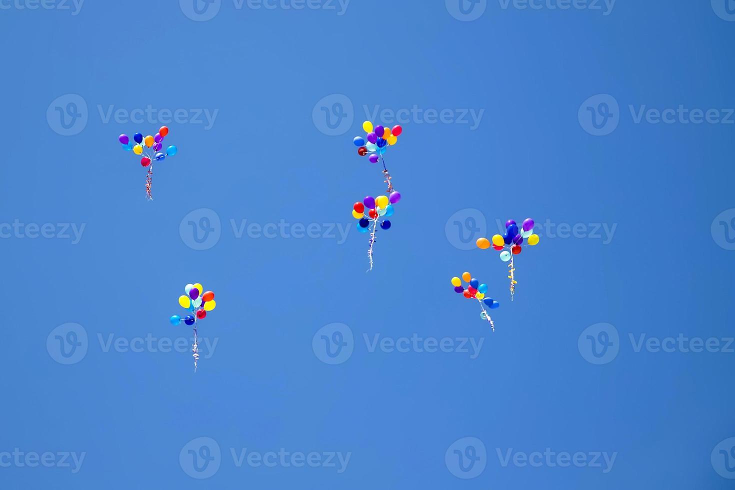 The multi colored helium balloons flying In the blue sky. the concept of a wedding, celebration, anniversary, entertainment photo