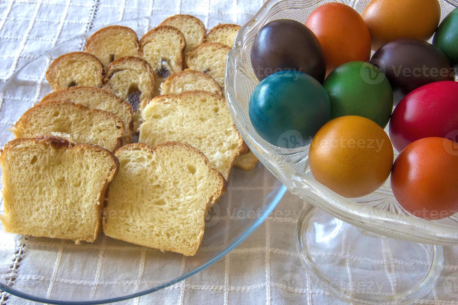 Easter traditional bread and colorful Easter eggs in a plate on the table photo
