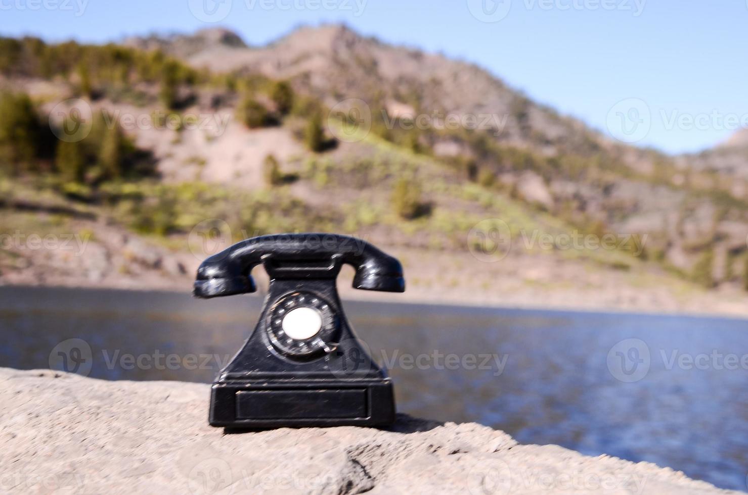 Old telephone on a rock photo