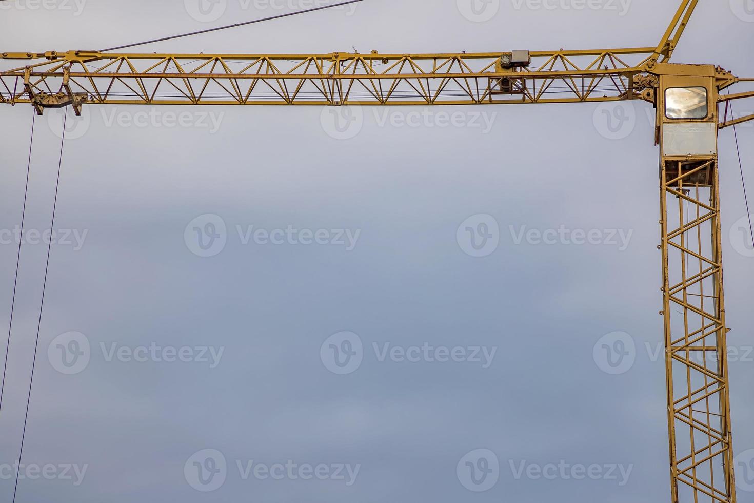 Construction crane tower on blue sky background. Empty Space for text. Construction concept. photo