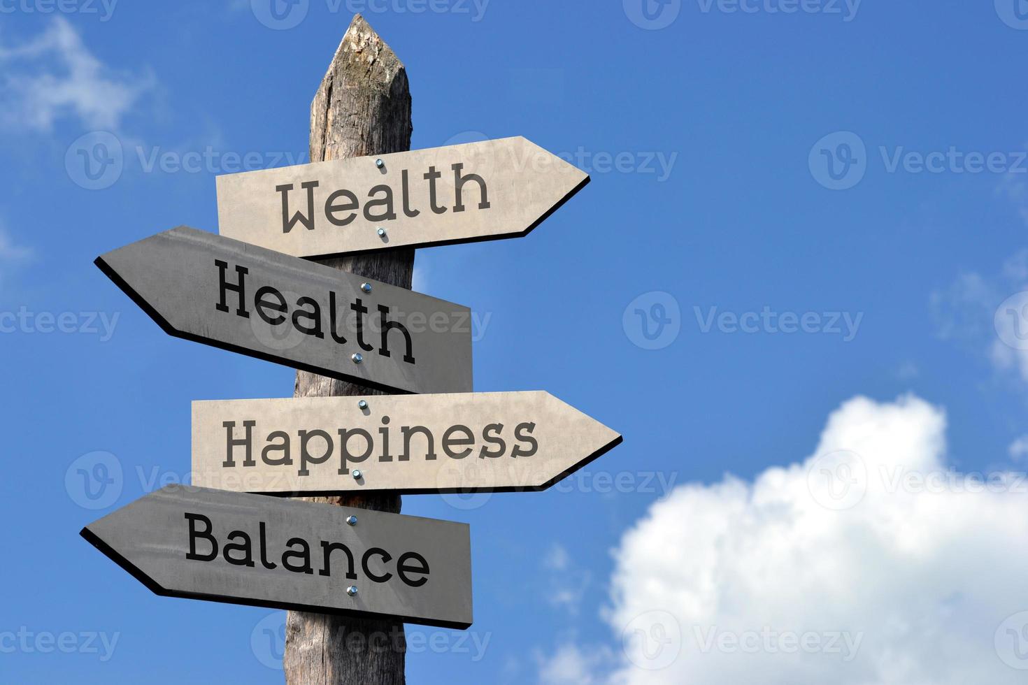 Happiness, Wealth, Health, Balance - Wooden Signpost with Four Arrows, Sky with Clouds photo