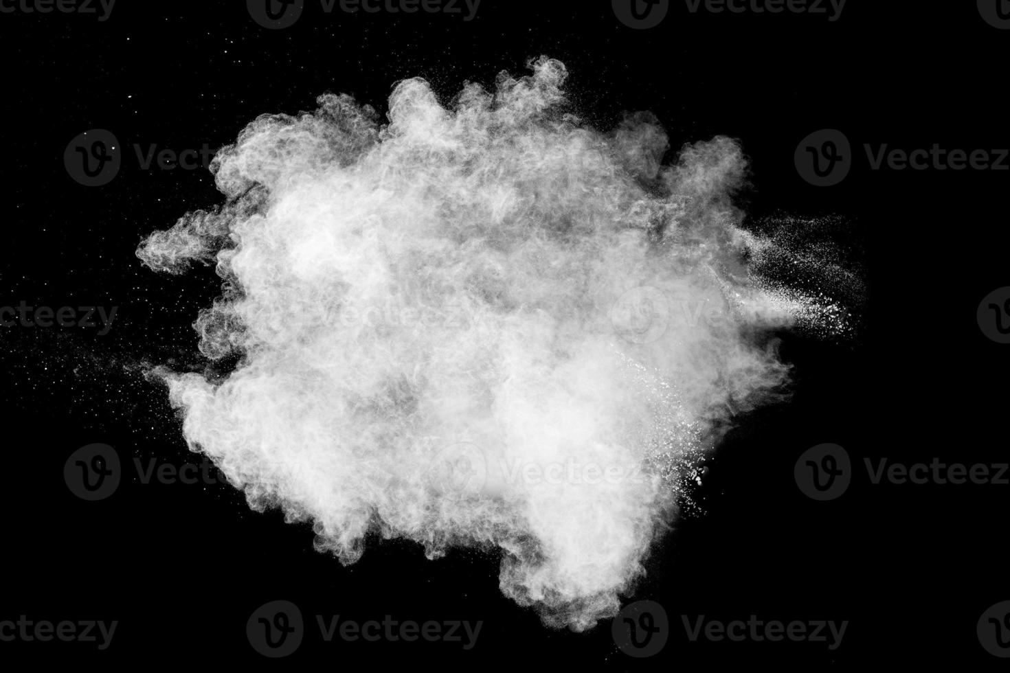 nube de explosión de polvo blanco sobre fondo negro. salpicaduras de partículas de polvo blanco. foto