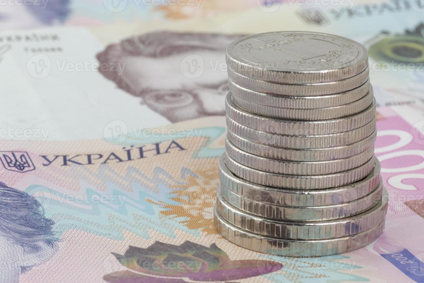 pila de ucranio hrivnya monedas en pie en billete de banco foto