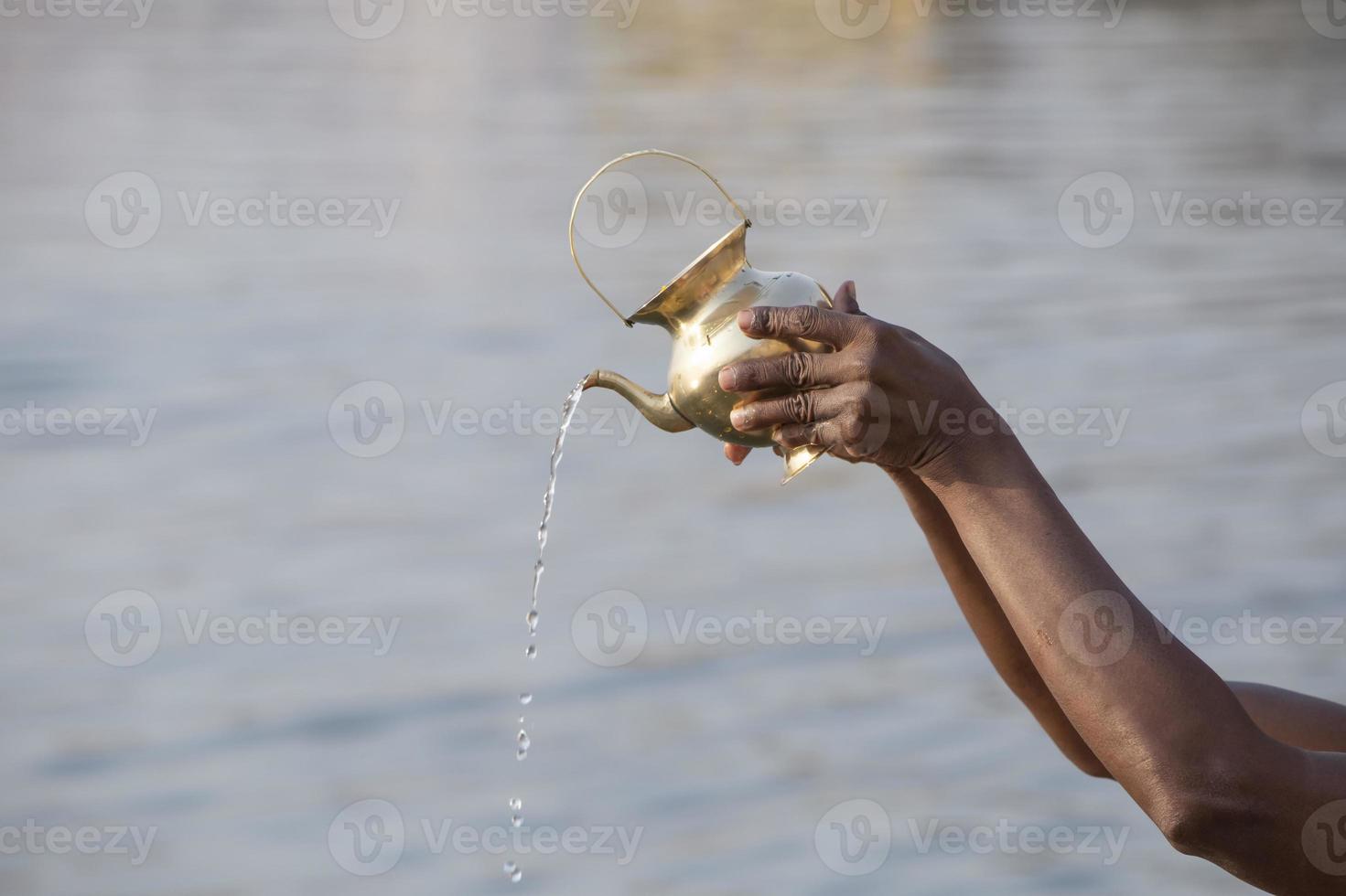 hands of hindu performing morning puja ritual at Ganges river photo