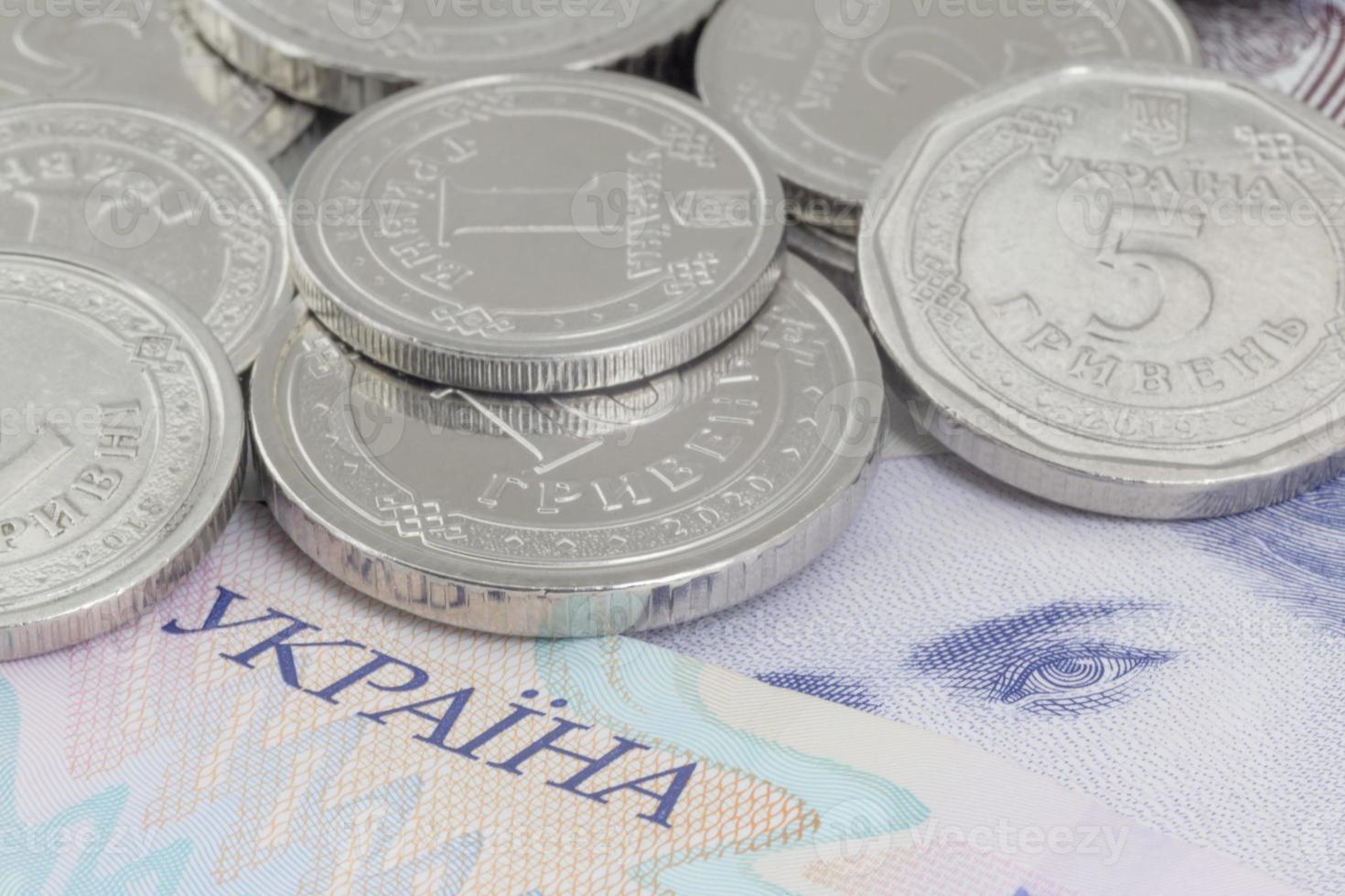 ucranio hrivnya monedas acostado en billetes foto