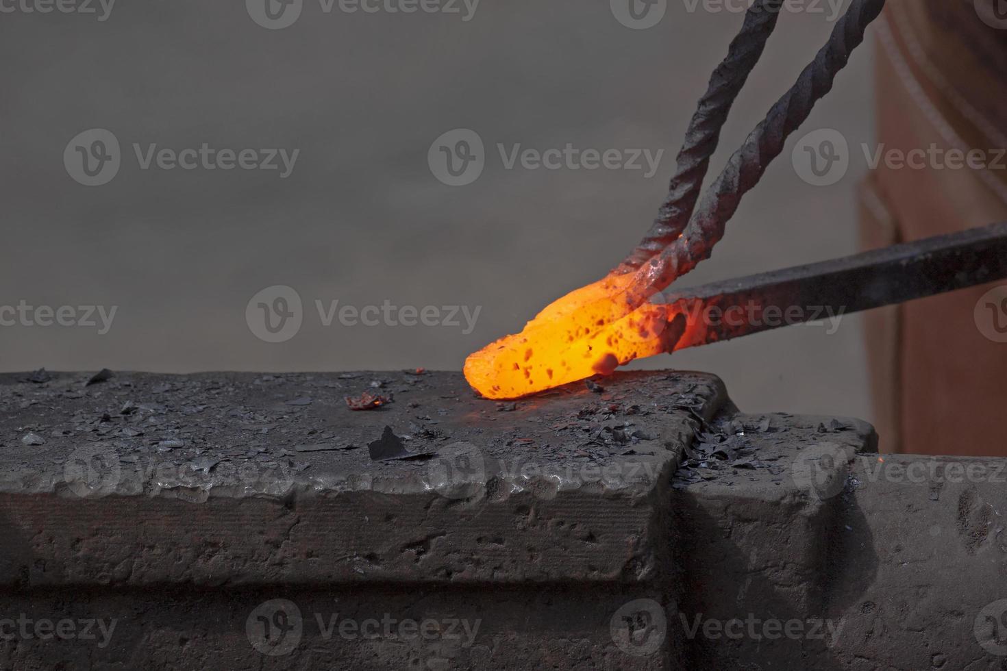 calentamiento metal varilla en yunque en fragua foto