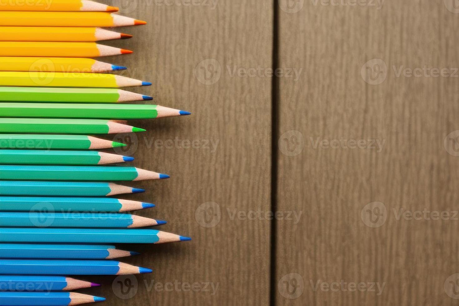 colorful pencils on wooden table, top view of brown table photo