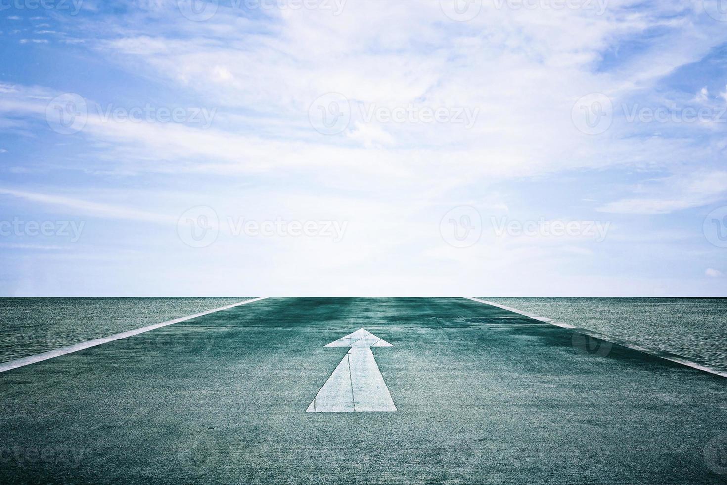 White Arrow on the Road Straight to Clouds and Blue Sky Background, Suitable for Business Successful Concept. photo