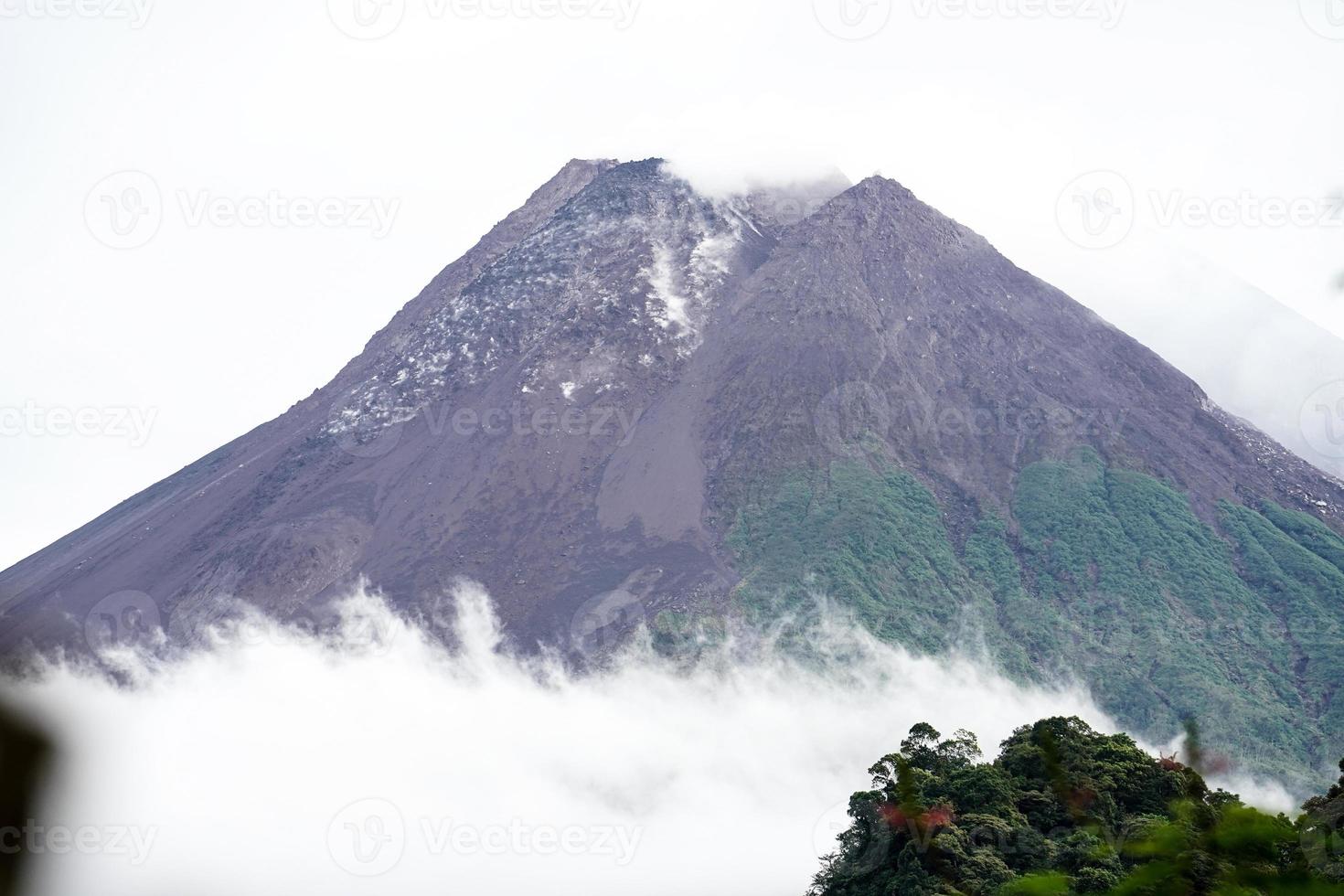 View of Mount Merapi in the morning, and slightly covered by clouds. Potentially eruptive volcano. photo