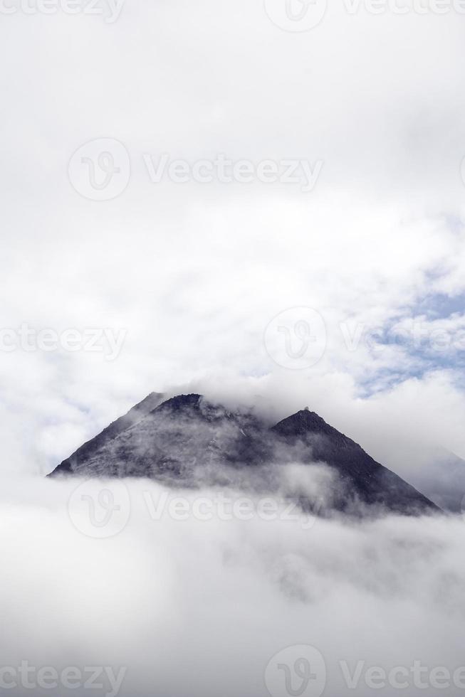 The dramatic view of Mount Merapi covered in clouds is very dense. Mountains that have the potential to erupt. photo