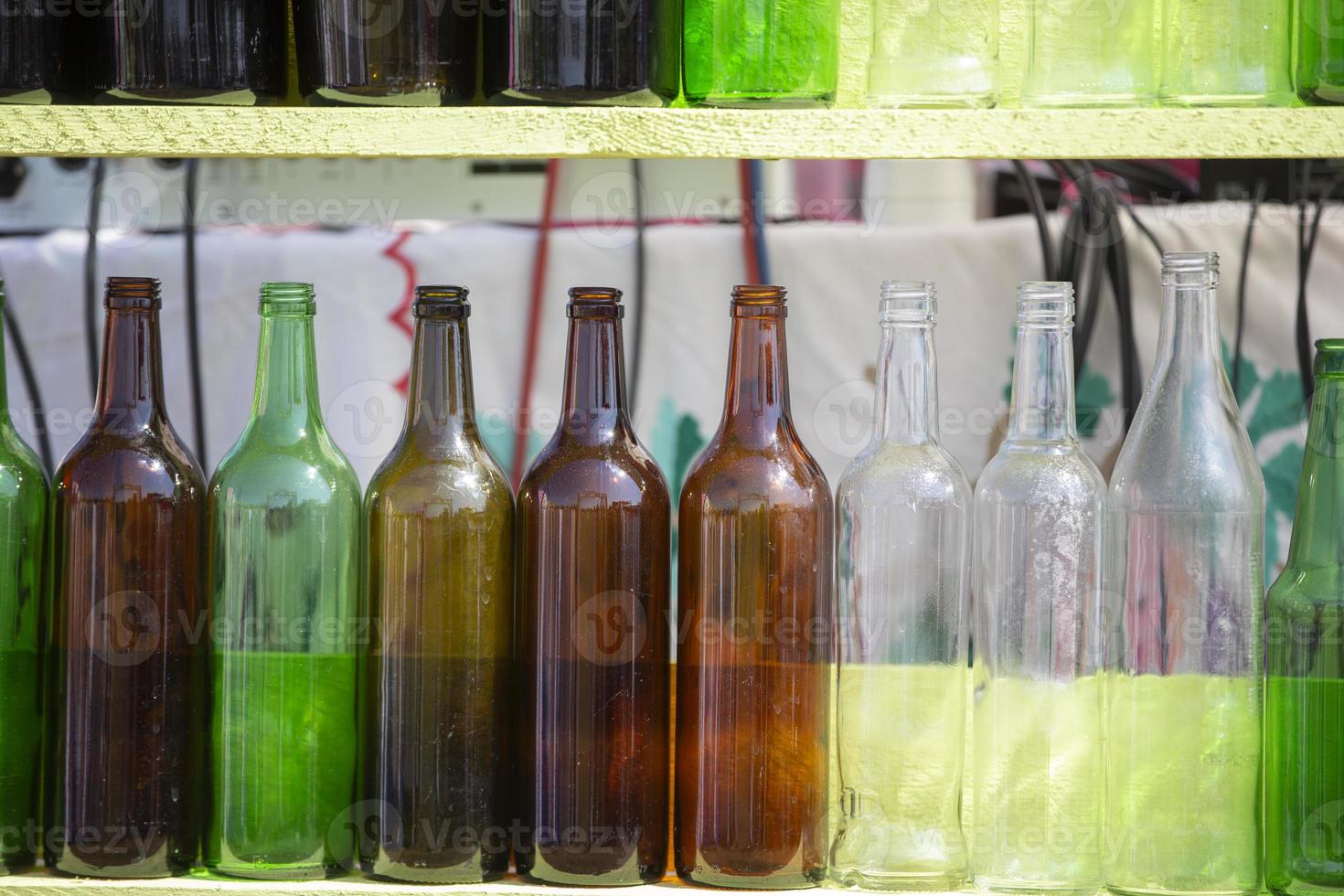 Vintage glass multi-colored bottles are in a row. photo